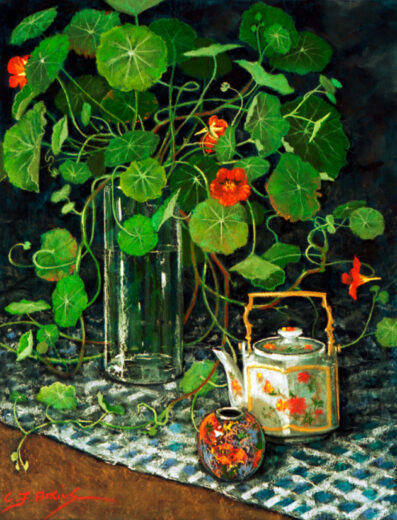 Nasturtiums spill out of a glass vase. Other ceramic objects are also present.