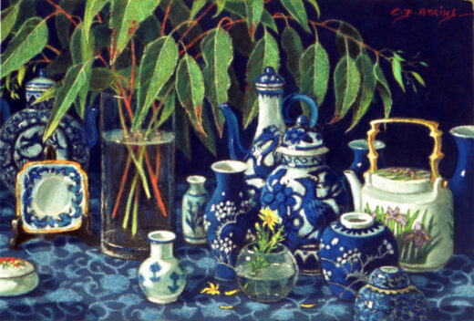 A collection of blue and white pottery stands in front of eucalypt leaves.